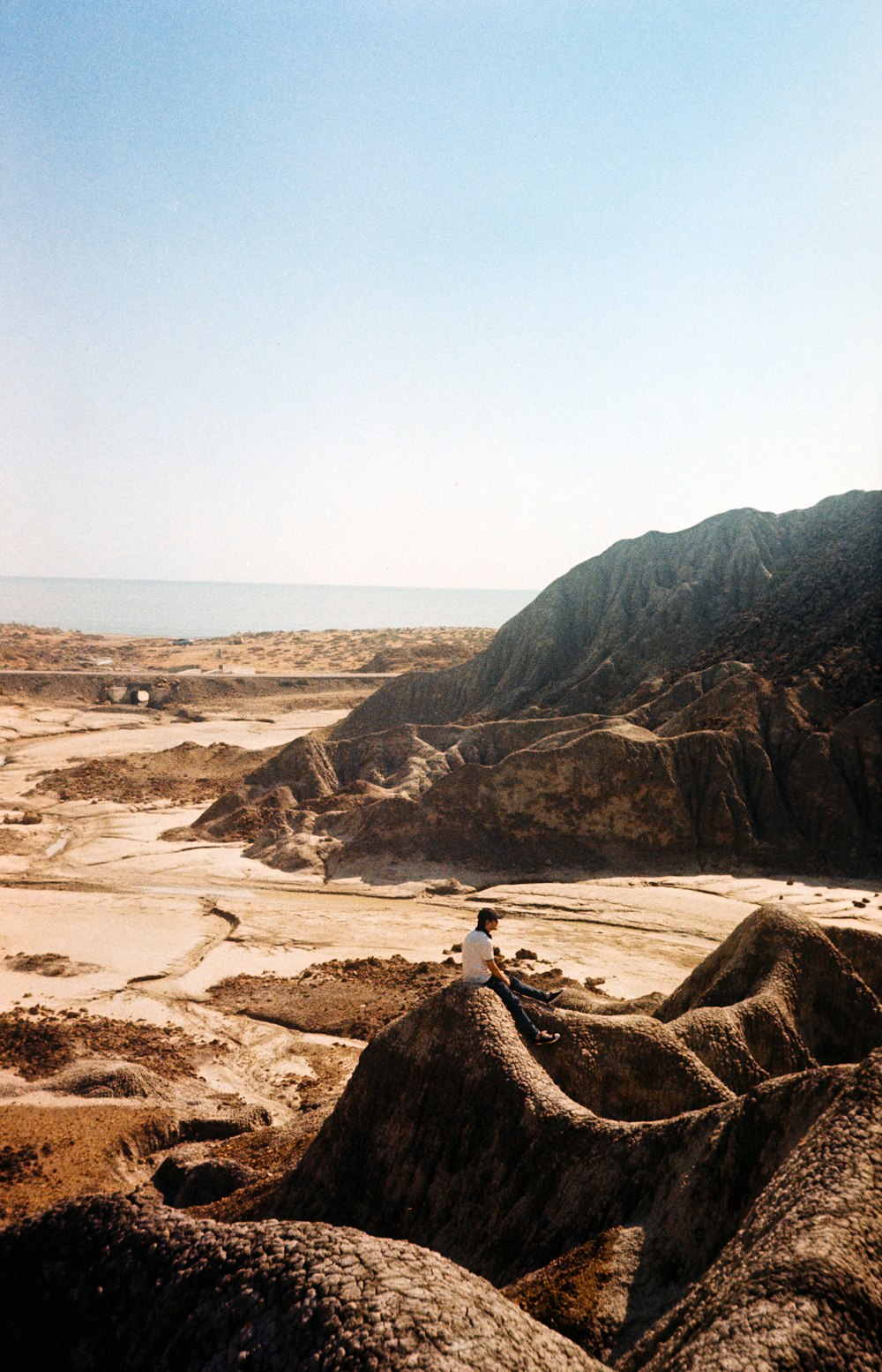 a person sitting on top of a large rock