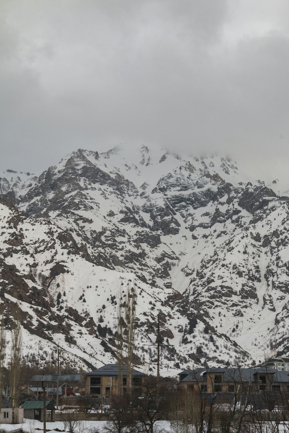 a snow covered mountain with houses in the foreground