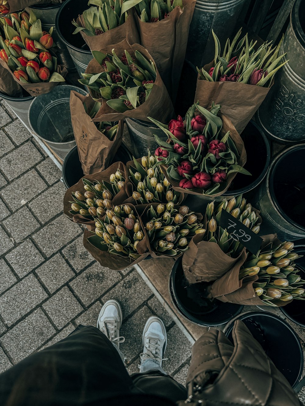 a person standing next to a bunch of flowers