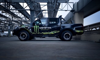 a monster truck is parked under a bridge