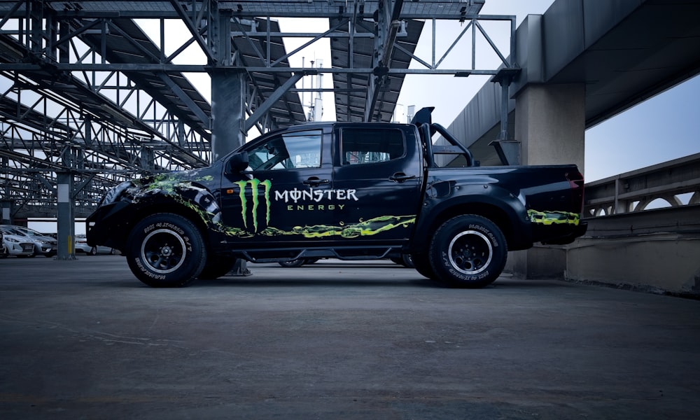 a monster truck is parked under a bridge