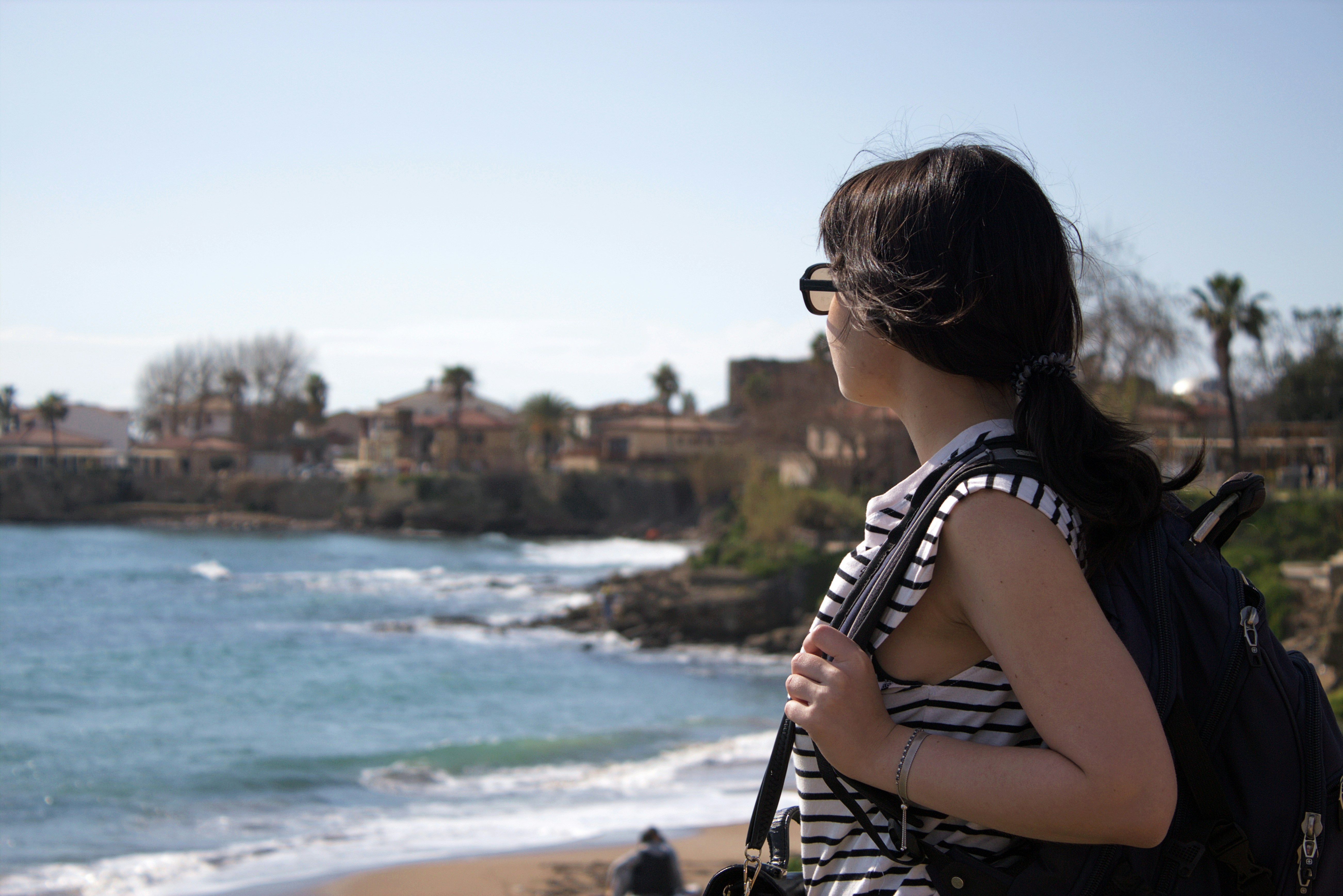 A woman standing on a beach looking at the ocean photo – Free Girl ...