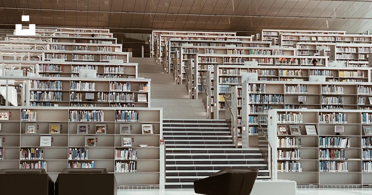 A library filled with lots of books next to a staircase photo – Free ...