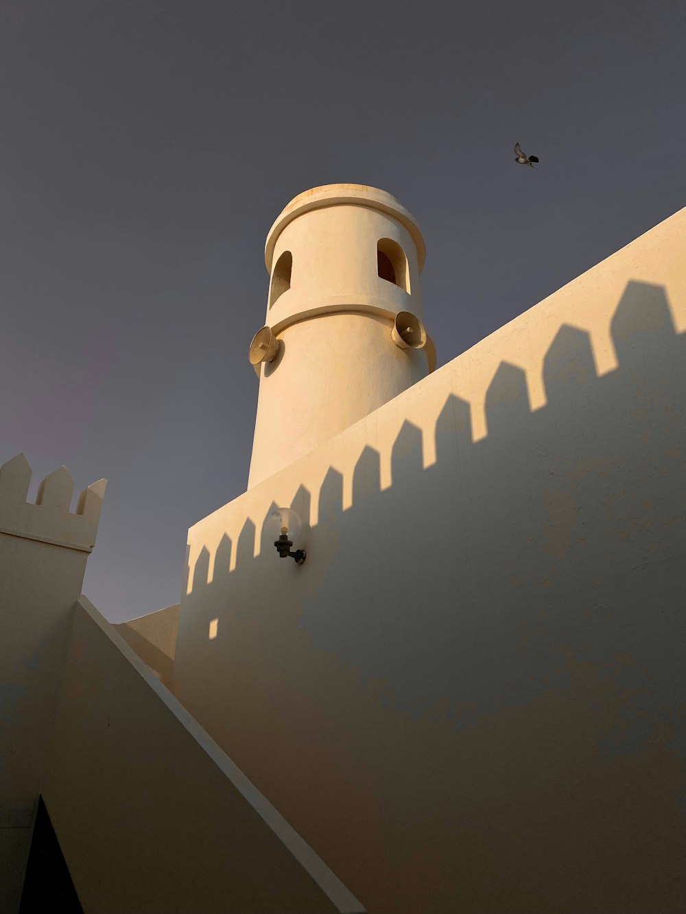 a tall white building with a clock on it's side