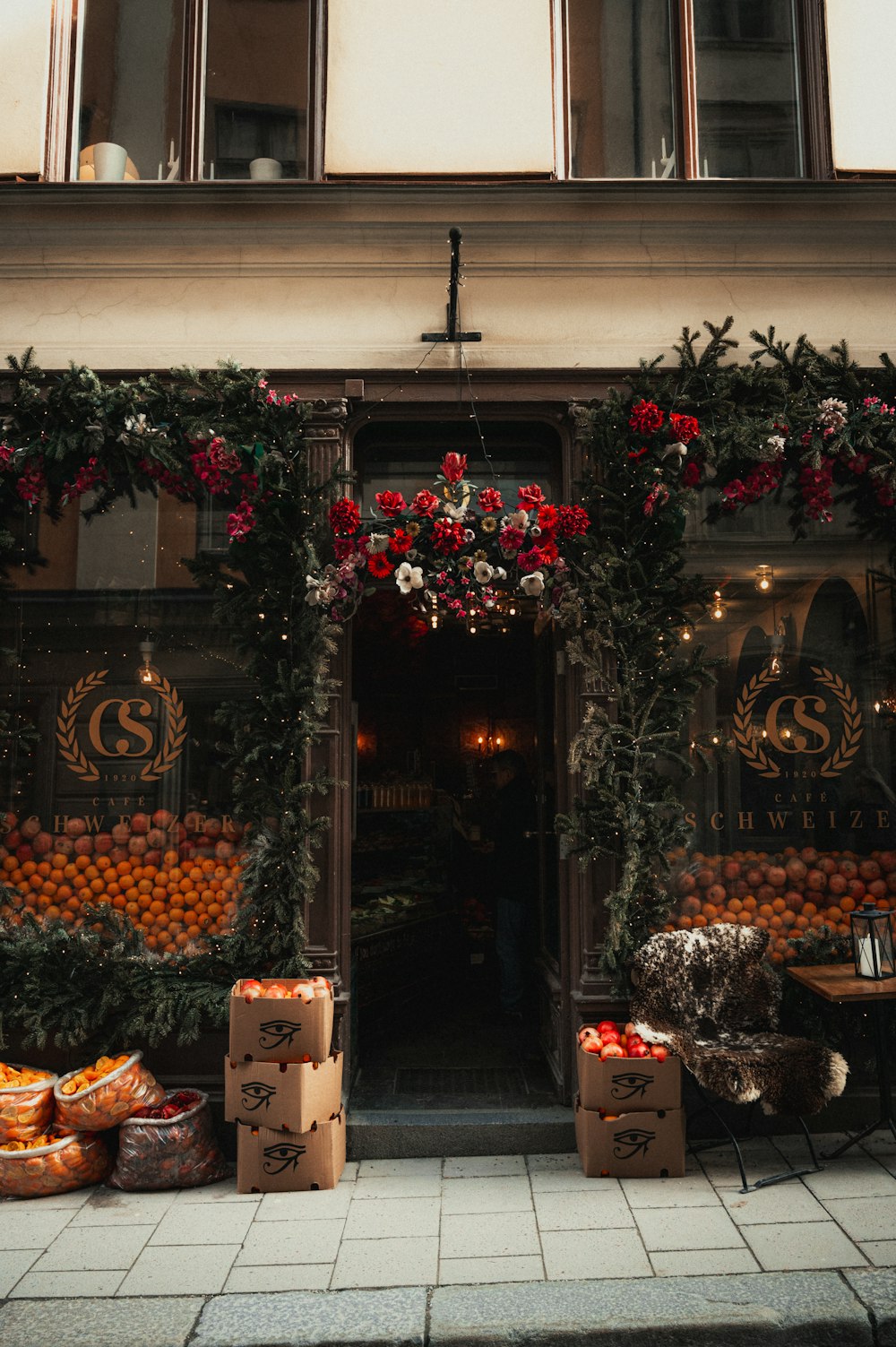 Un escaparate con cajas de frutas y flores