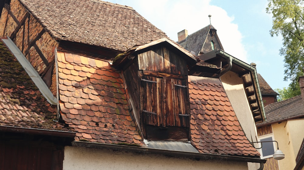 a building with a red tiled roof and wooden shutters