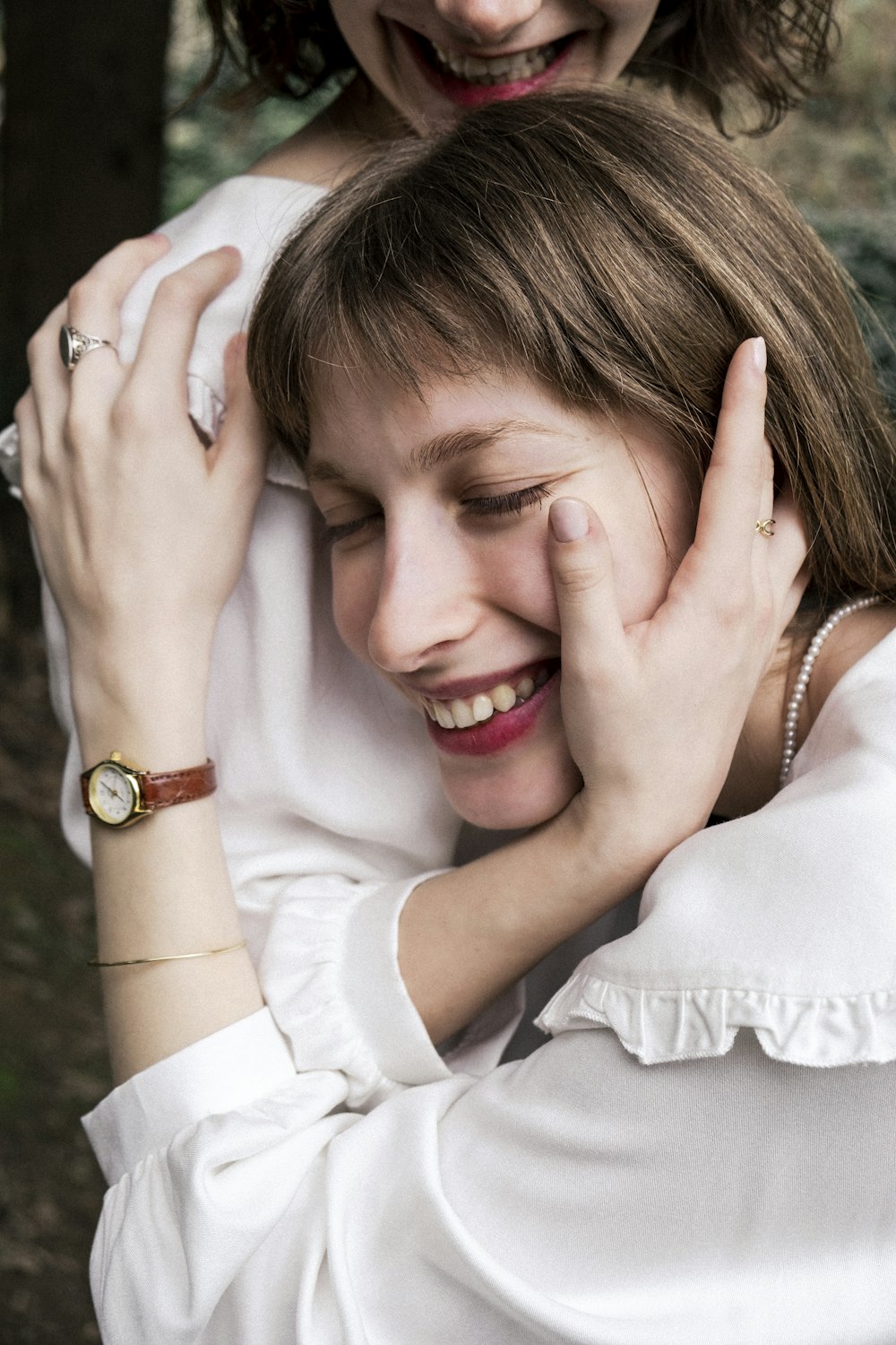 a woman is hugging another woman in a white dress