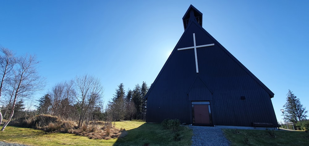 una chiesa nera con una croce in cima