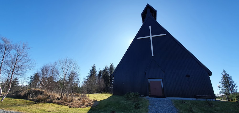 a black church with a cross on the top of it