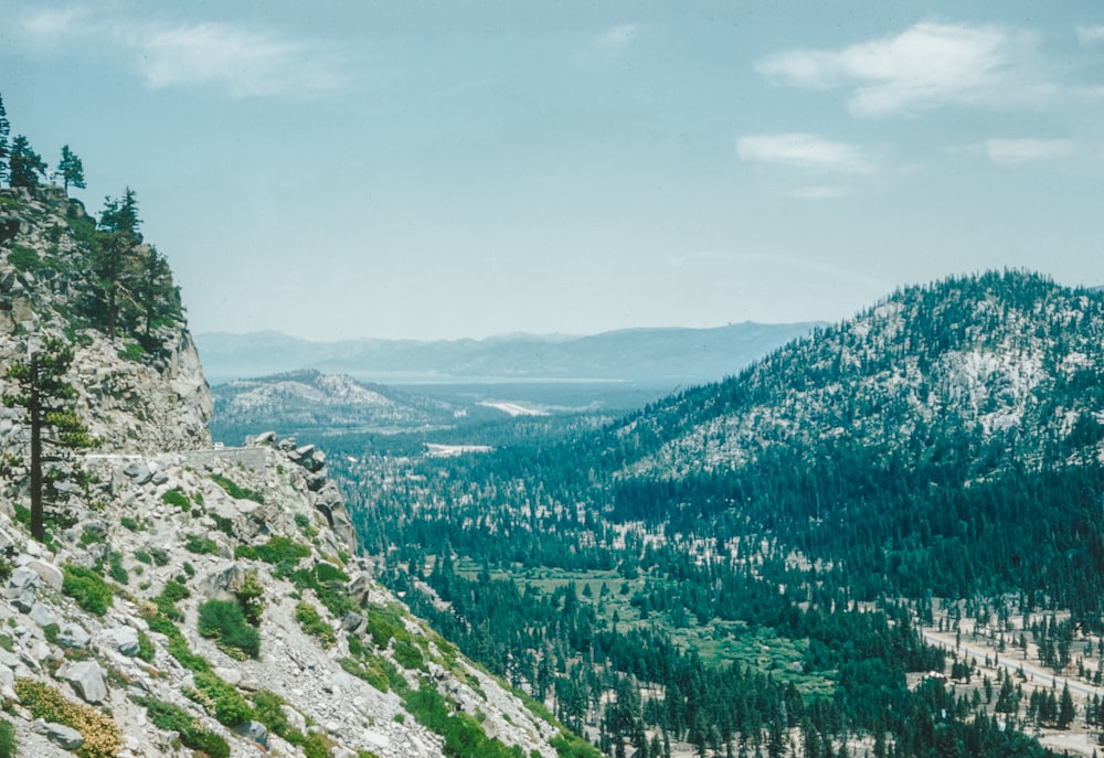 a view of a mountain range with trees and mountains in the background