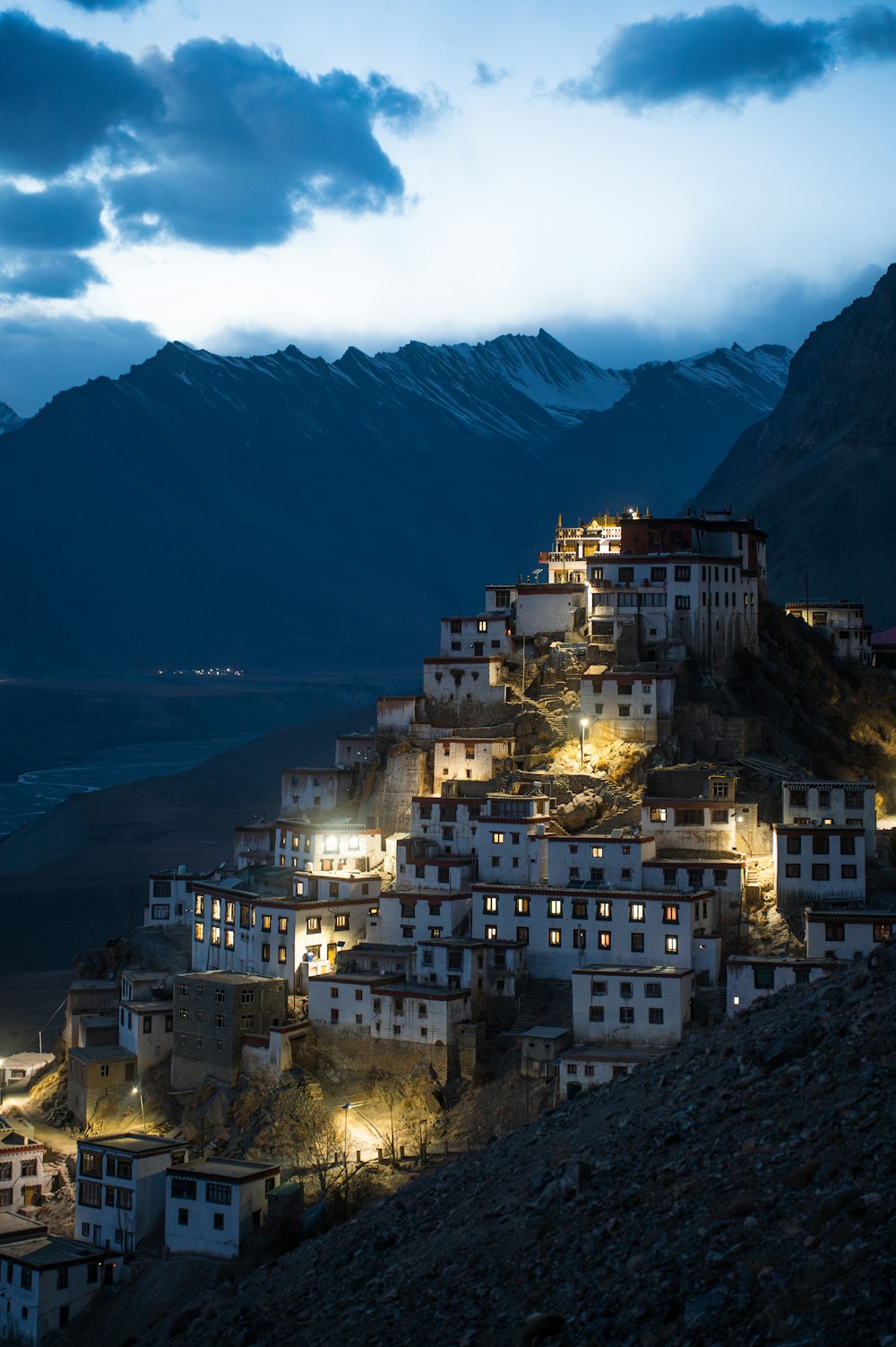 a mountain town lit up at night with mountains in the background
