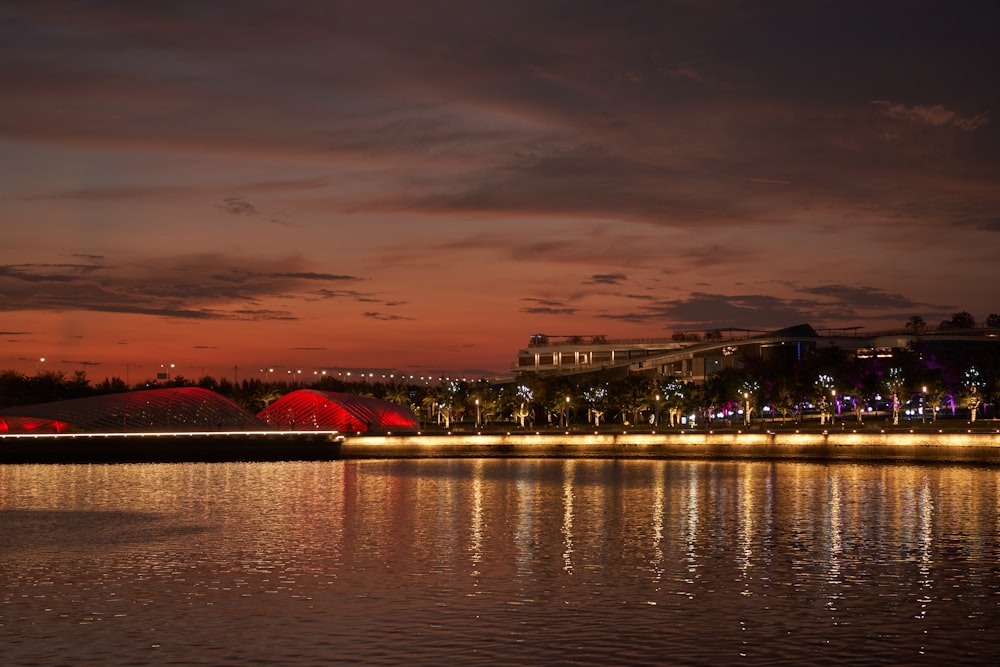 a body of water at night with lights reflecting off the water