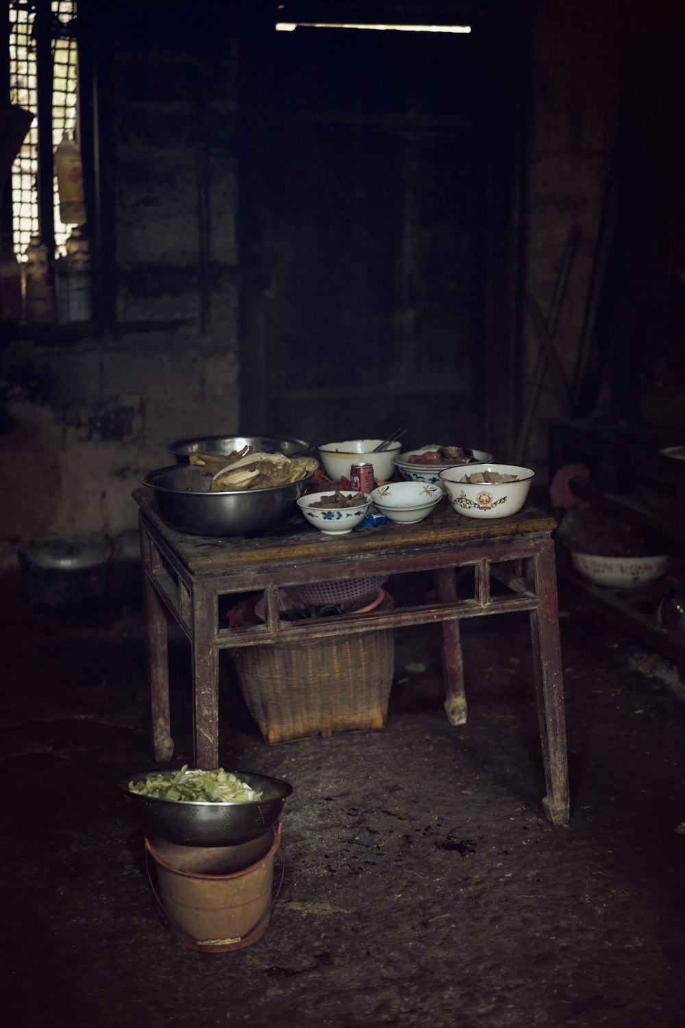 a wooden table topped with bowls of food