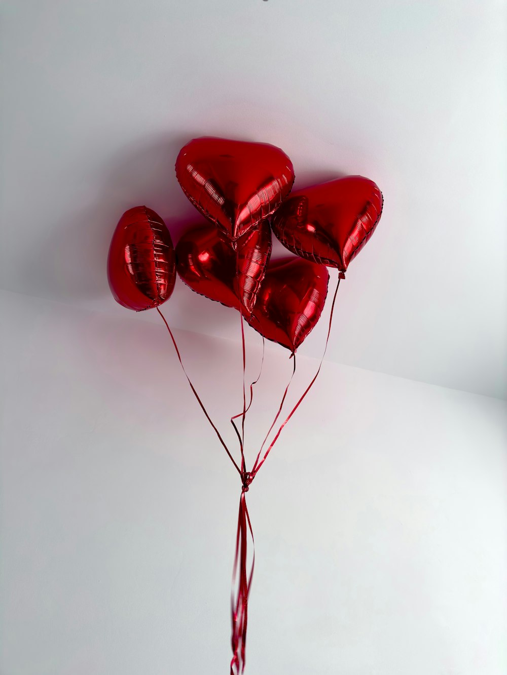 a bunch of red heart shaped balloons tied to a string