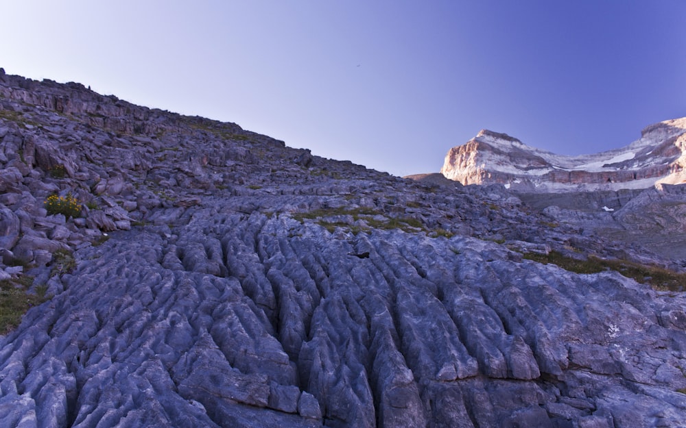 a rocky mountain side with a mountain in the background