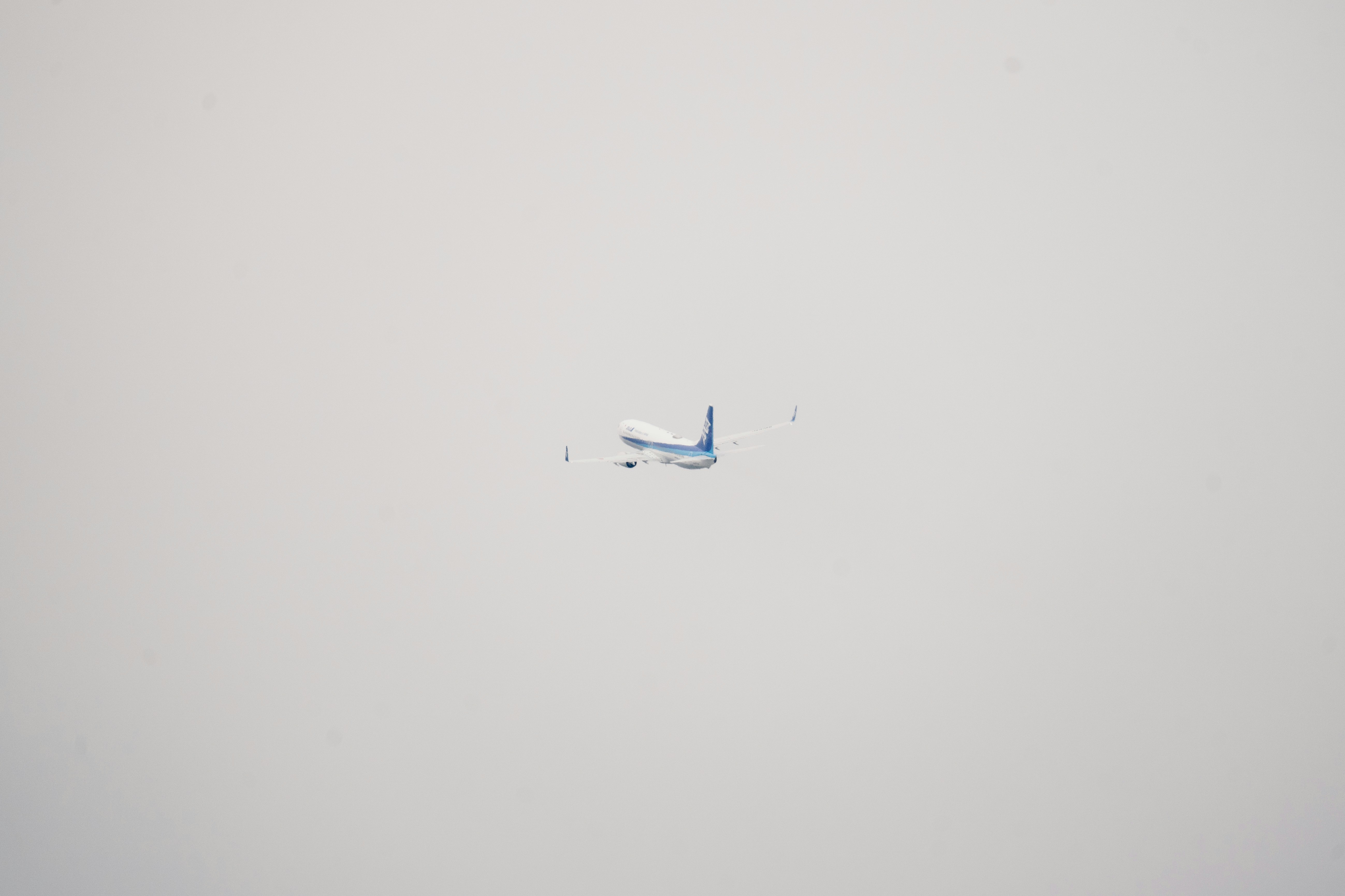 an airplane flying in the sky on a foggy day