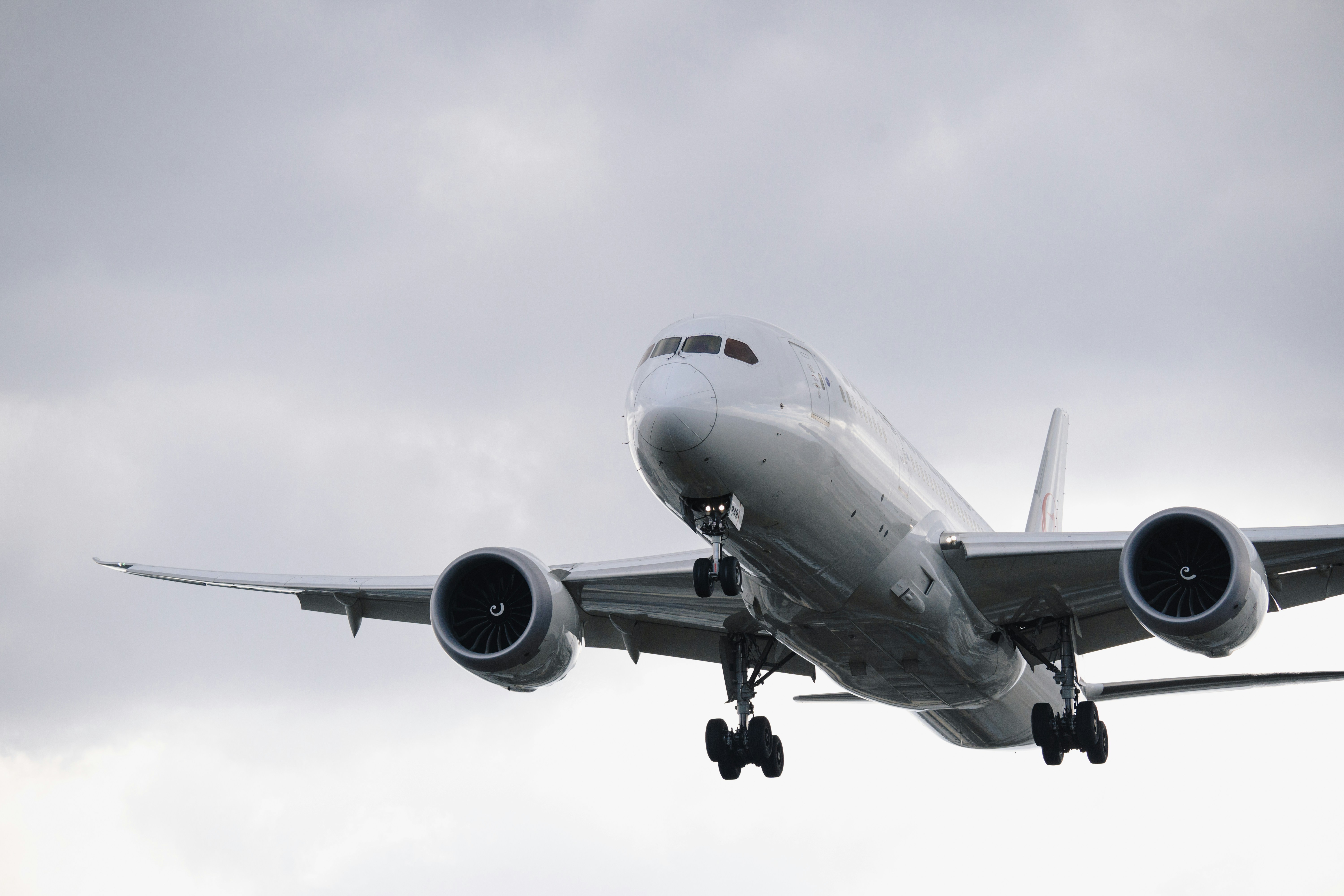 a large jetliner flying through a cloudy sky
