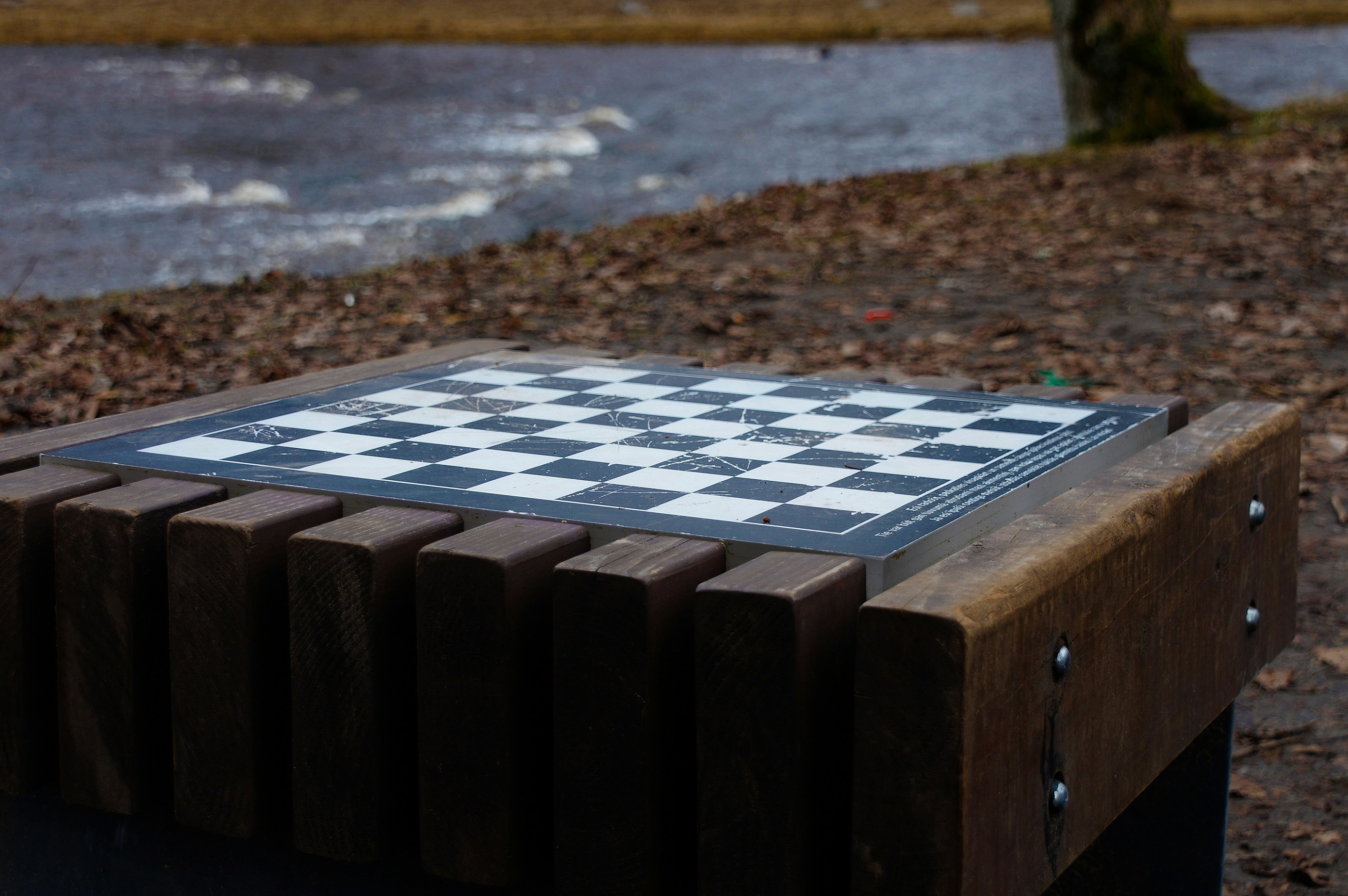 ein Schachbrett, das auf einer Holzbank sitzt