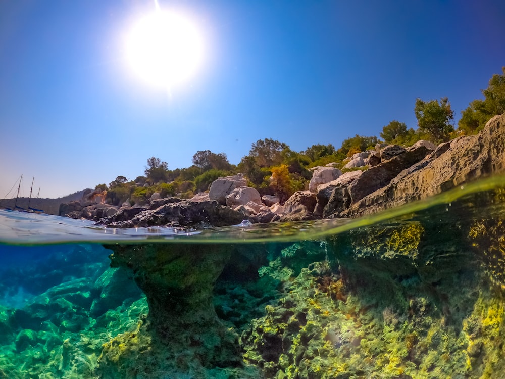 the sun is shining over the water and rocks