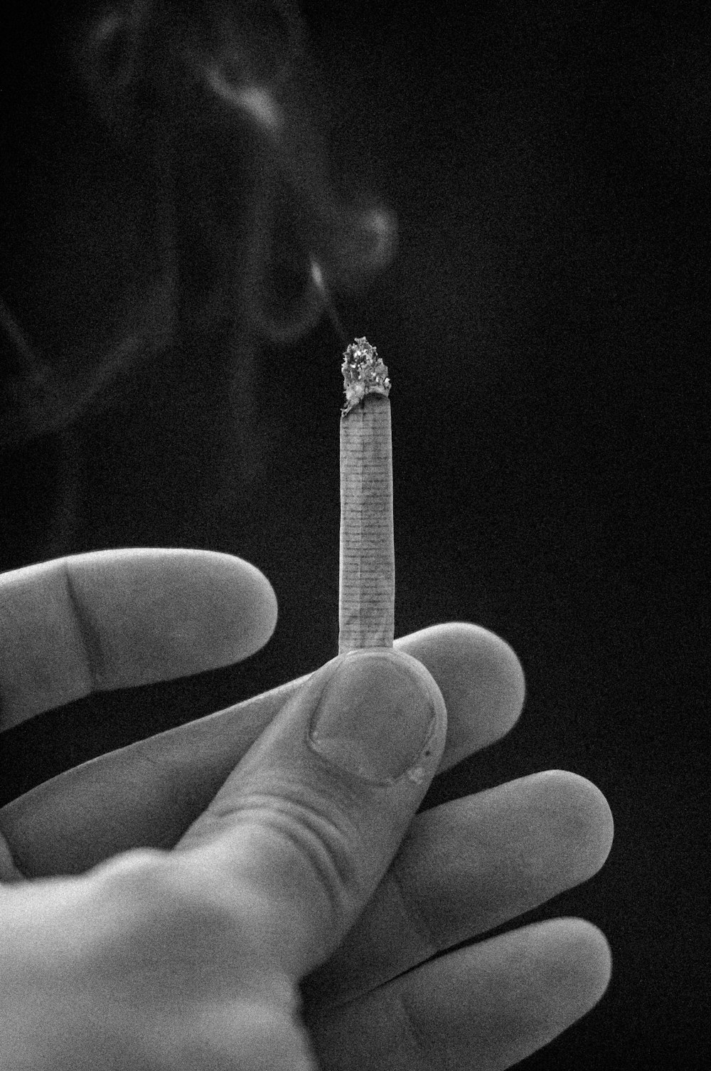 a person holding a cigarette in their hand
