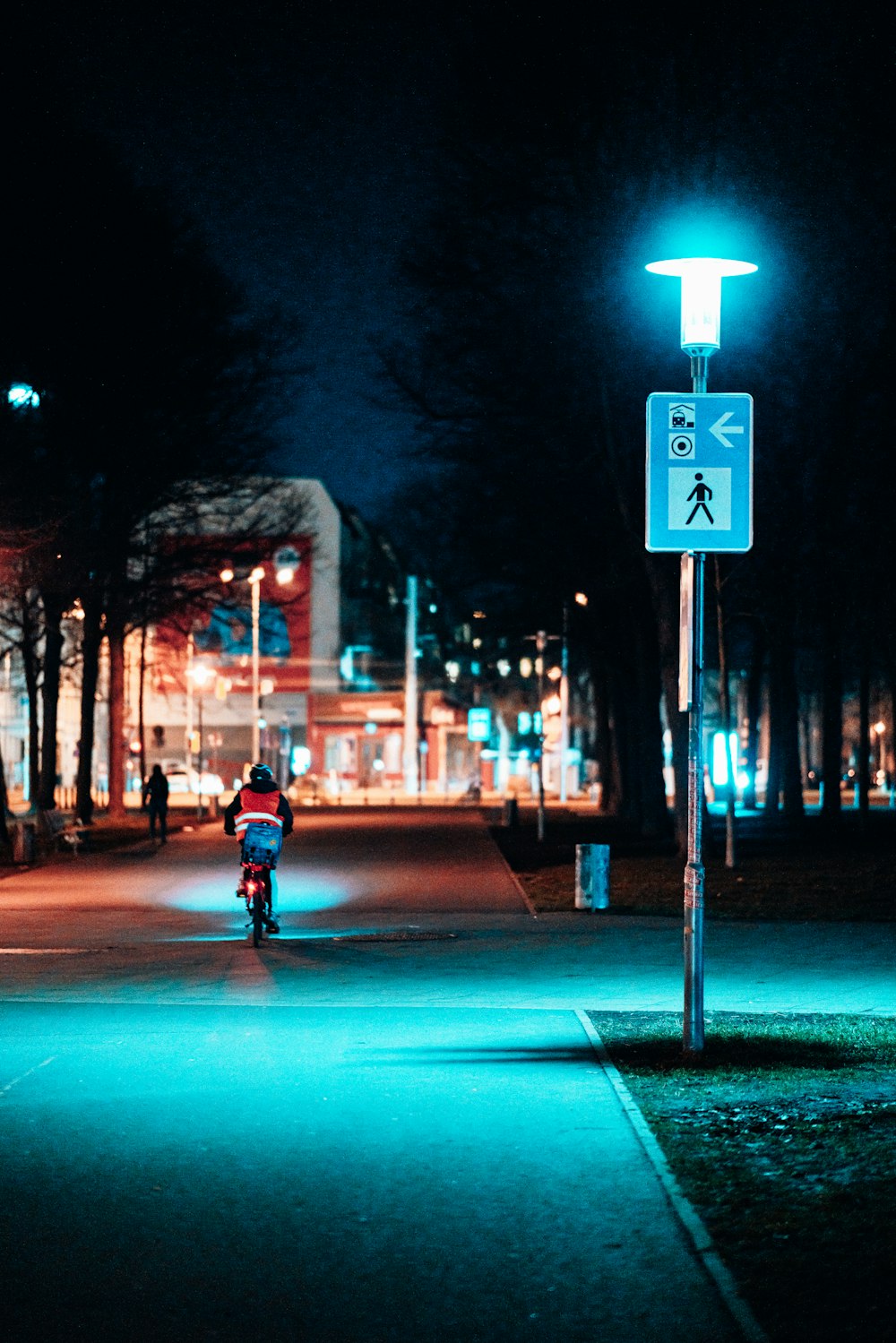 a person riding a bike down a street at night