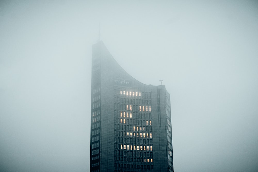 a very tall building in the middle of a foggy day