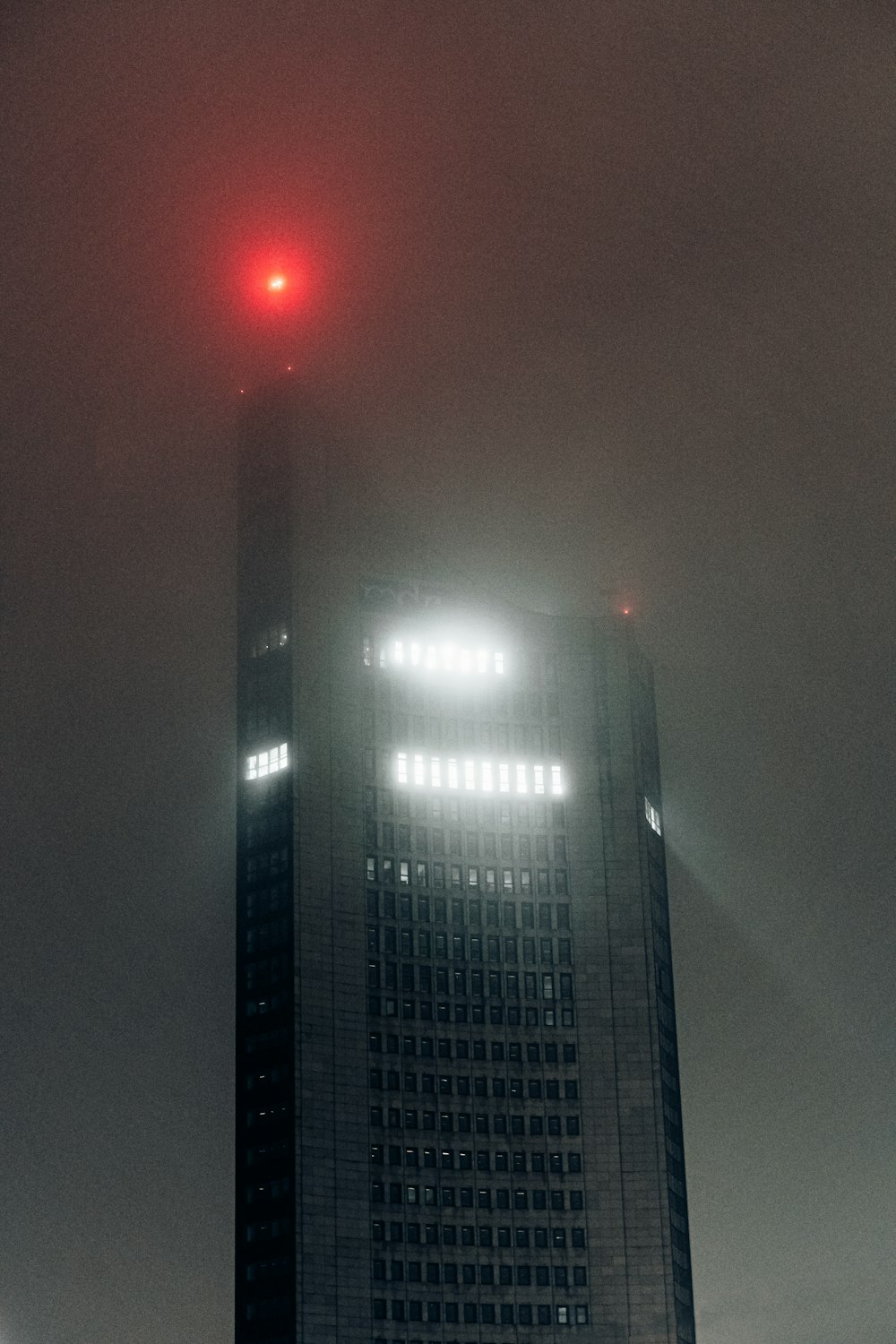 a tall building with a red light on top of it