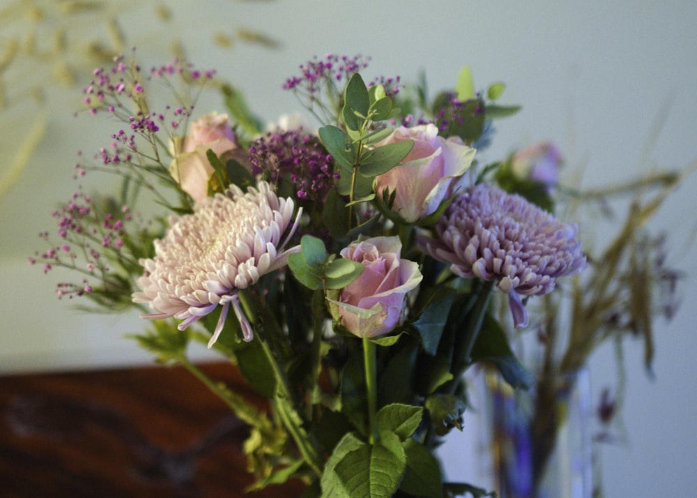 a vase filled with lots of flowers on top of a table