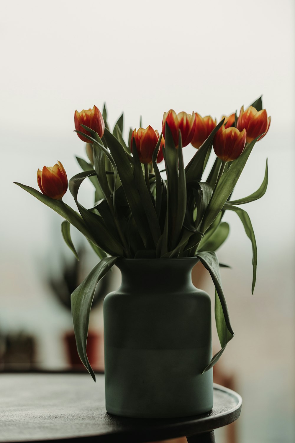 a vase filled with lots of flowers on top of a table