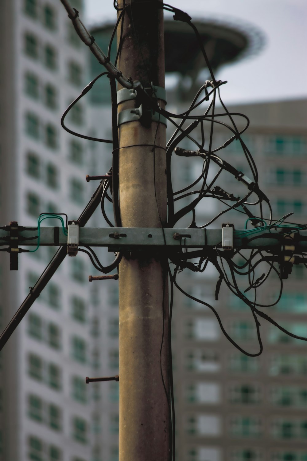 a close up of a telephone pole covered in wires