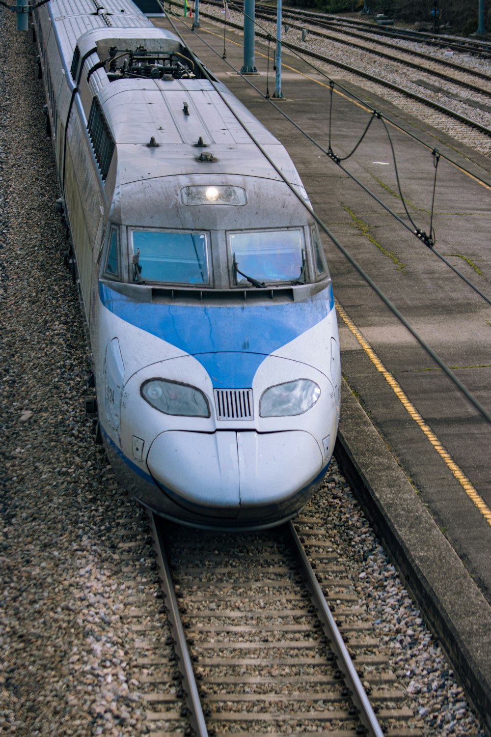 a blue and white train traveling down train tracks