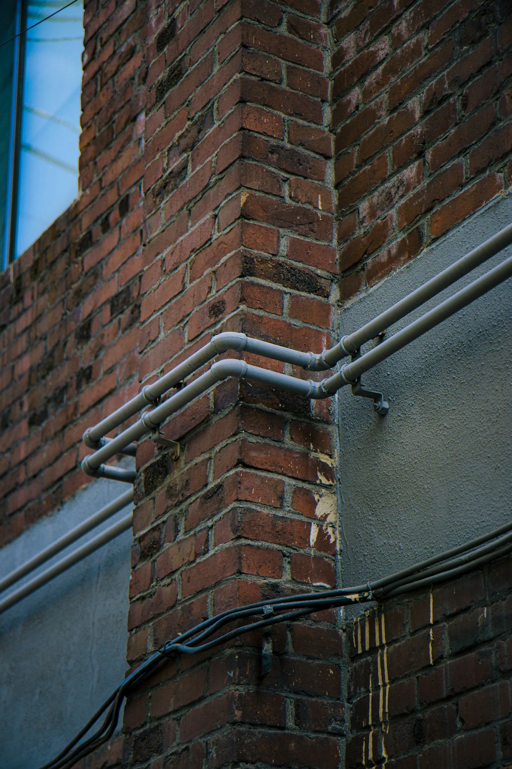 a brick building with a metal gutter attached to it