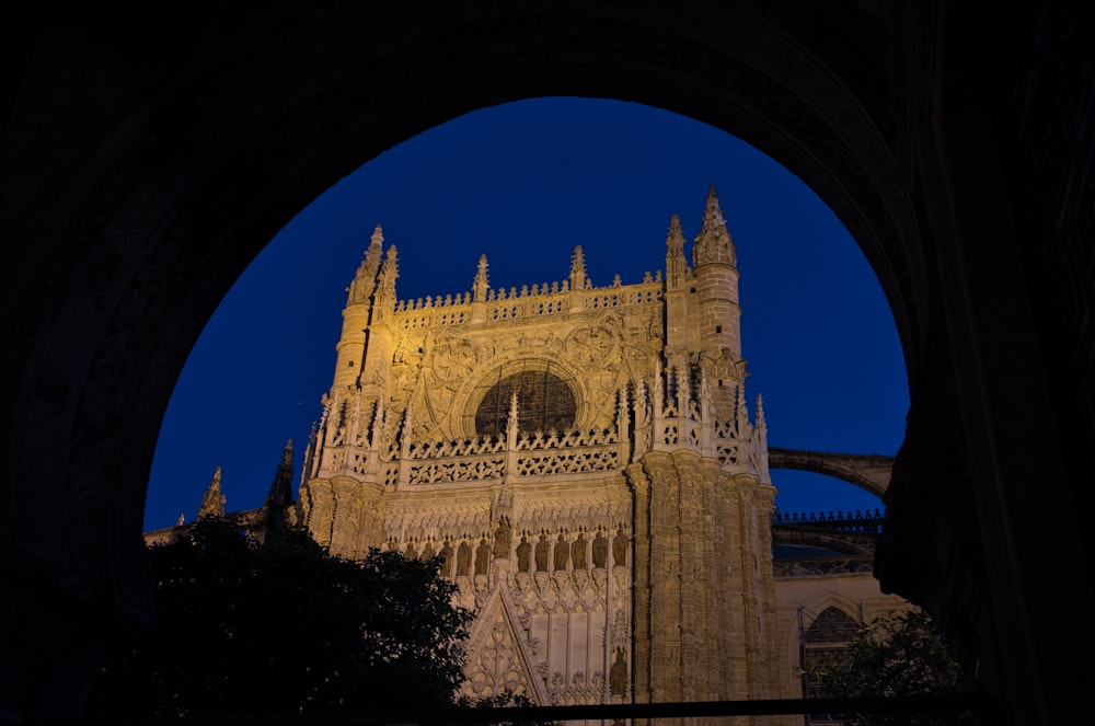 a cathedral lit up at night with a blue sky