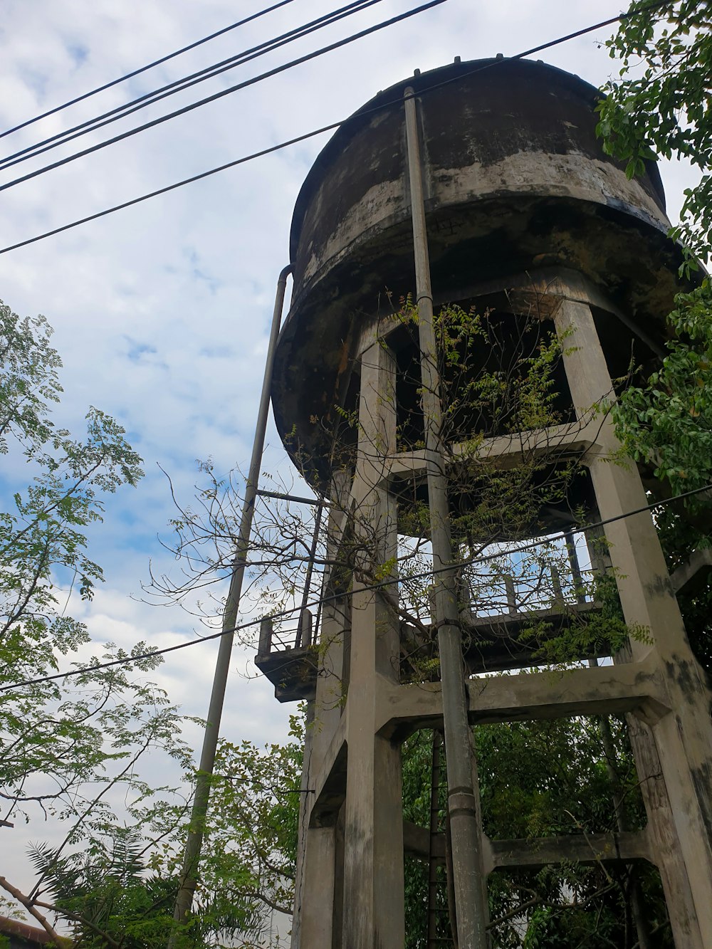 an old water tower with vines growing out of it