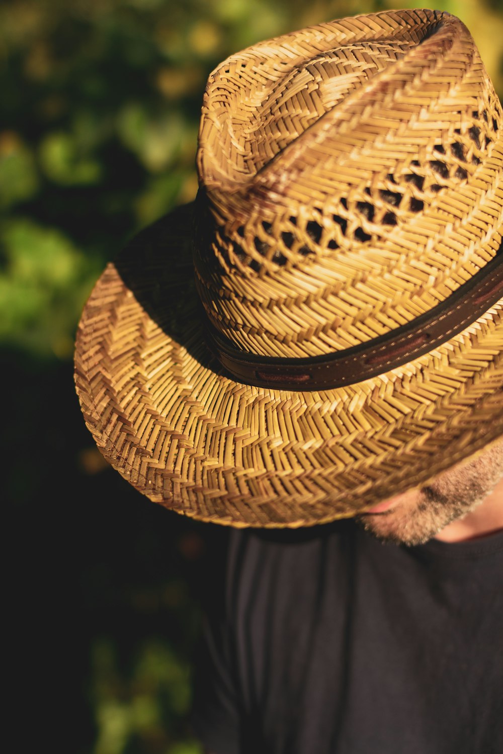 a man wearing a straw hat in a park