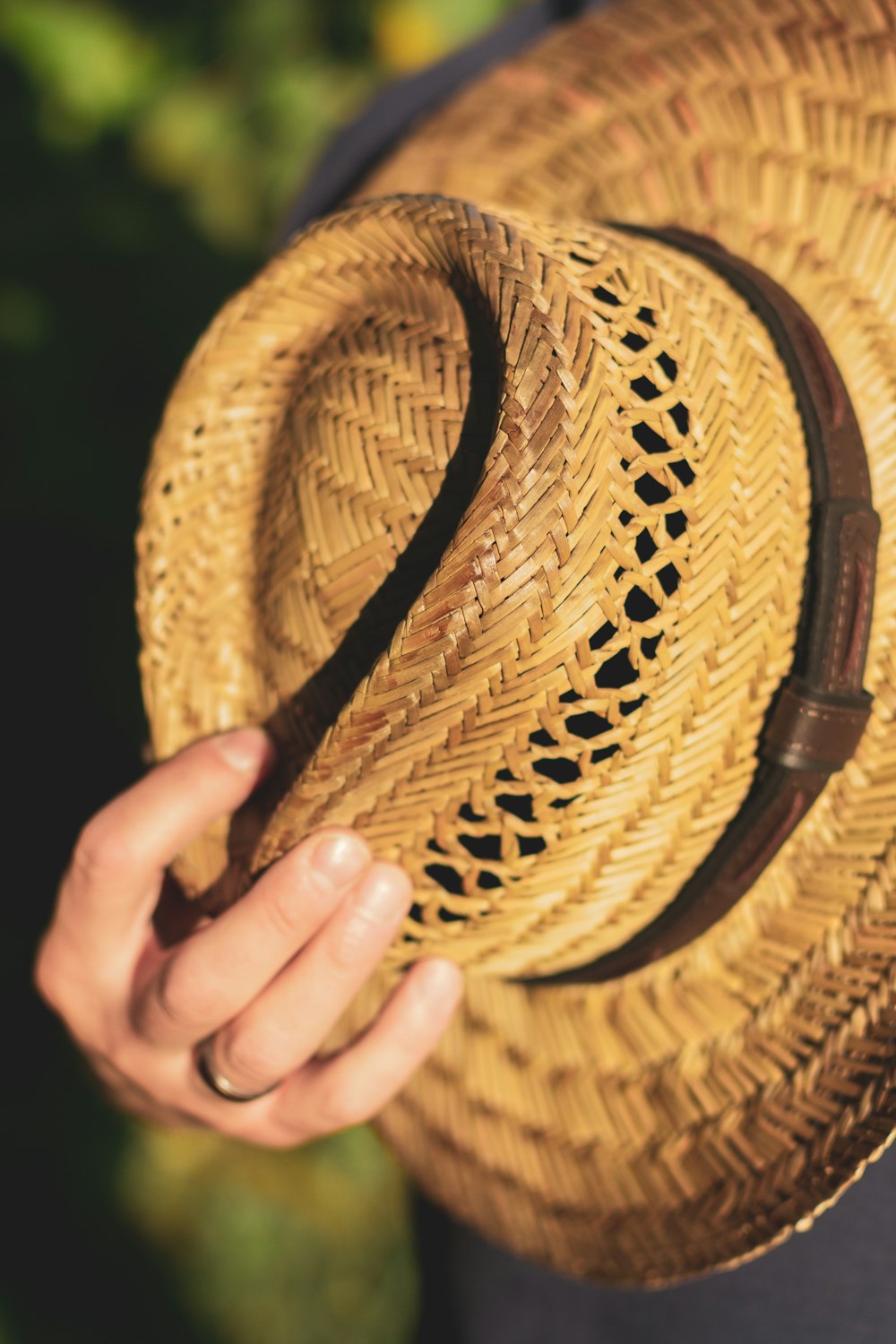 a close up of a person holding a straw hat