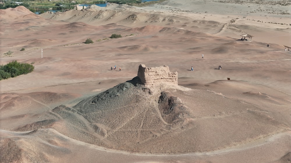an aerial view of a desert with a castle in the middle