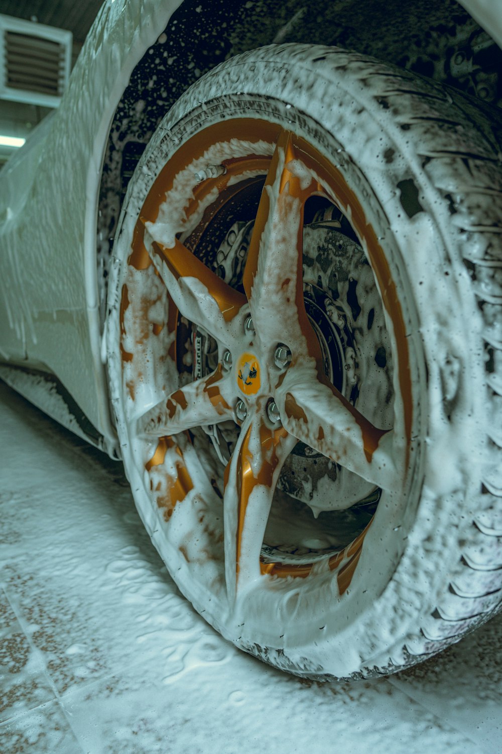una ruota di un'auto coperta di neve con vernice arancione e bianca