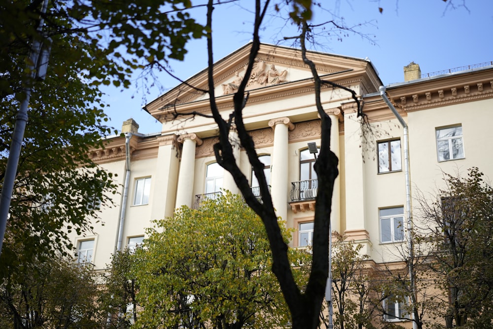 a large building with columns and trees in front of it