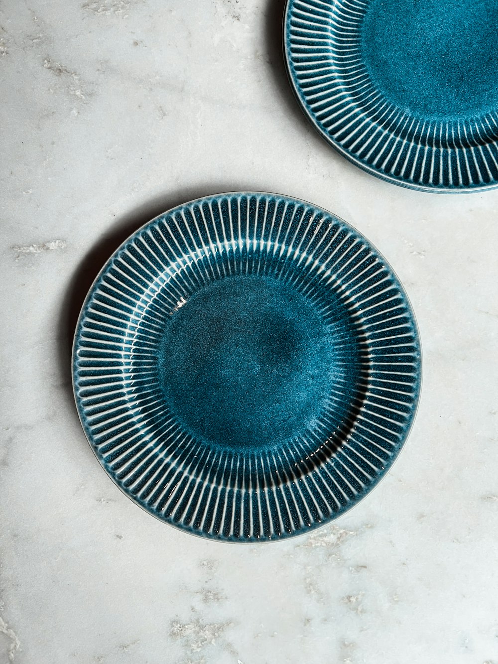 two blue plates sitting on top of a white counter