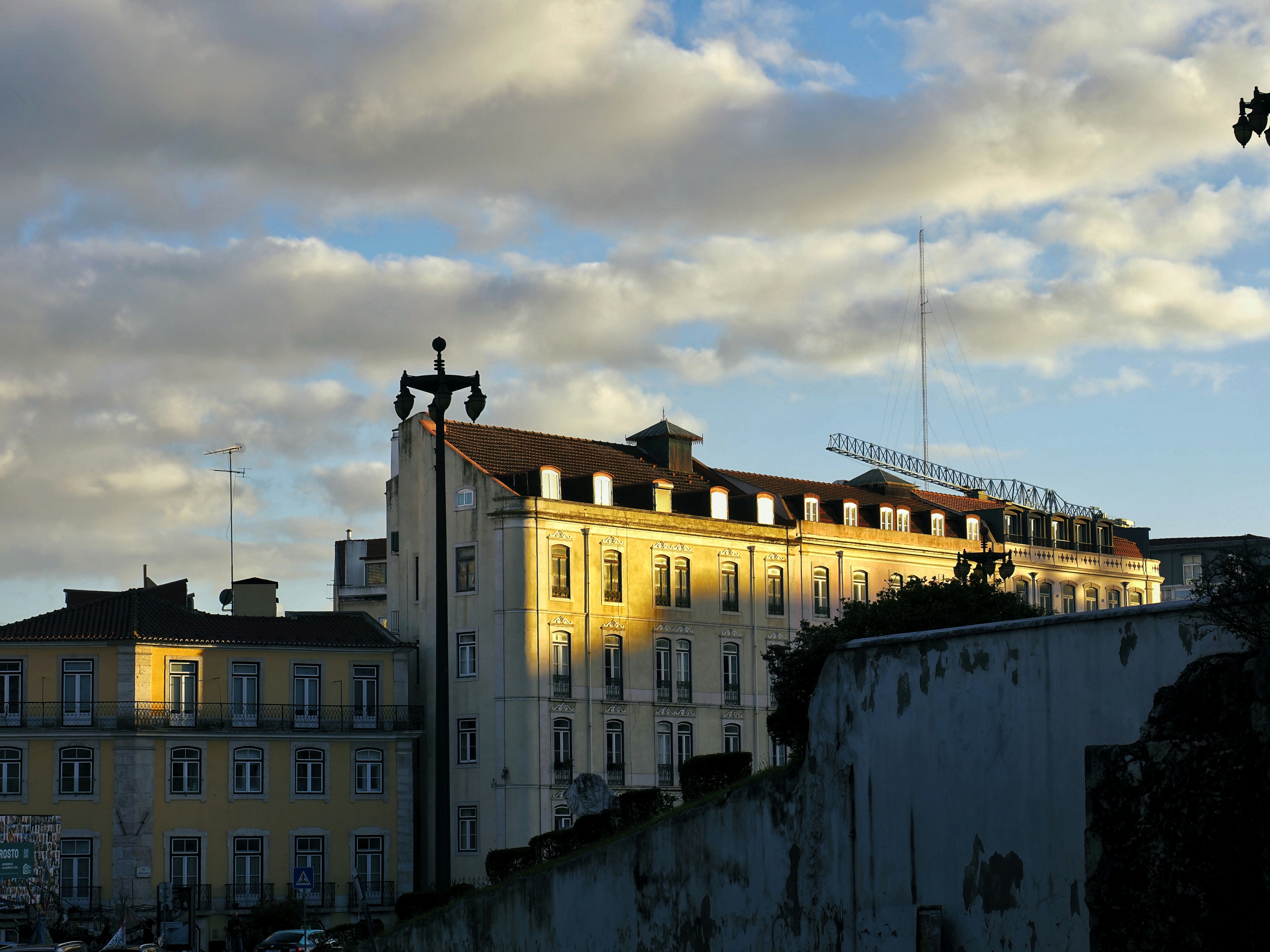 a tall building with a clock tower on top of it, Sunset lighting on buildings