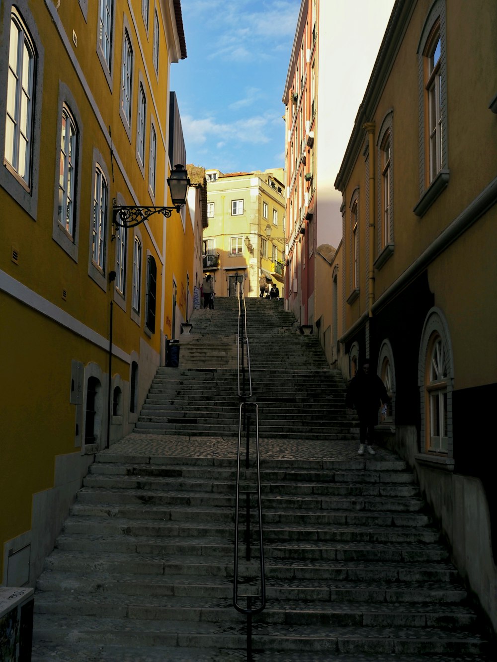 a set of stairs leading up to a yellow building