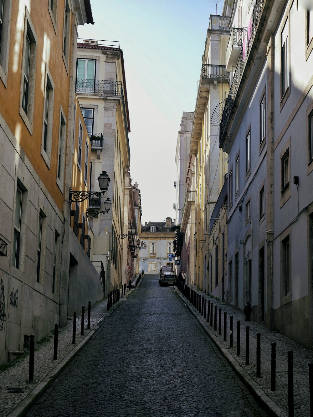 a narrow street lined with tall buildings in a city