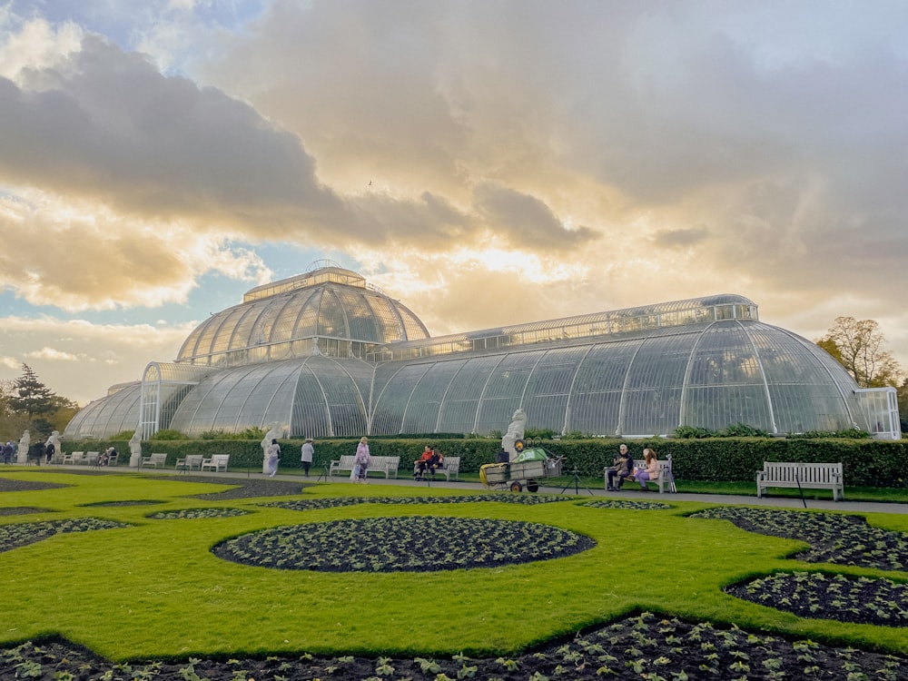 a green house with a circular garden in front of it