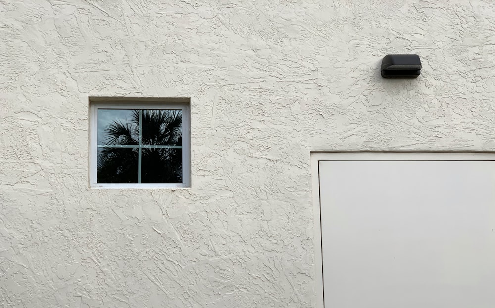 a white building with a window and a white door