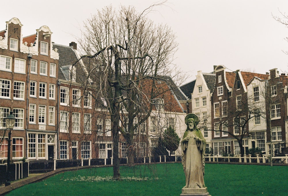 a statue stands in the middle of a grassy area