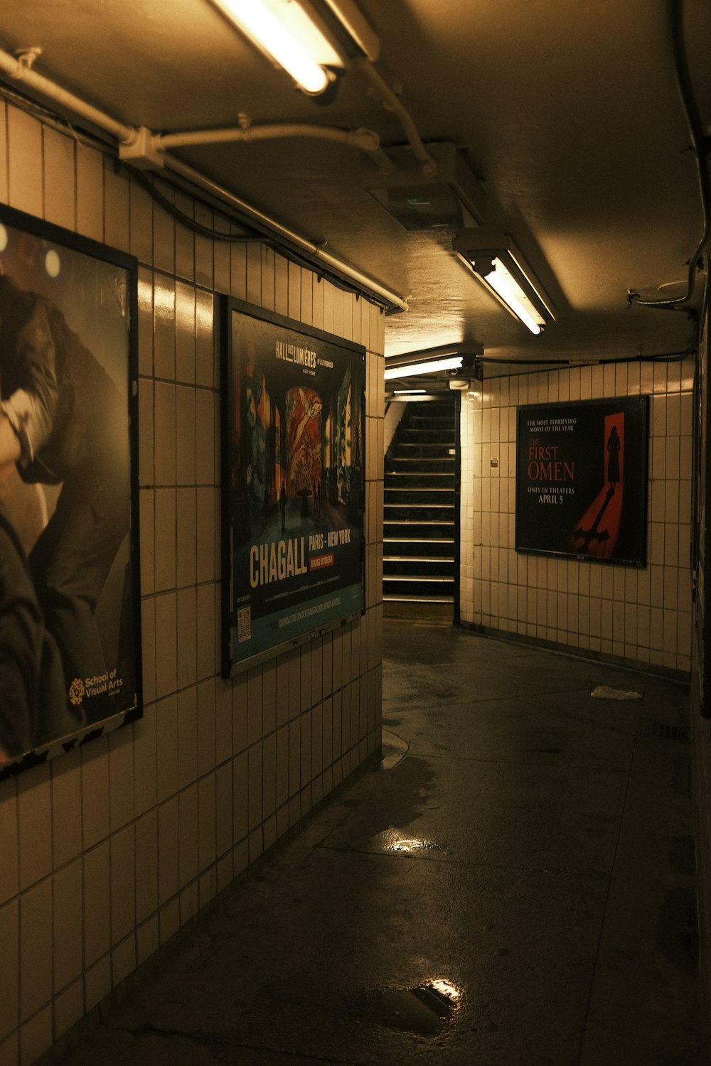 a subway station with posters on the wall