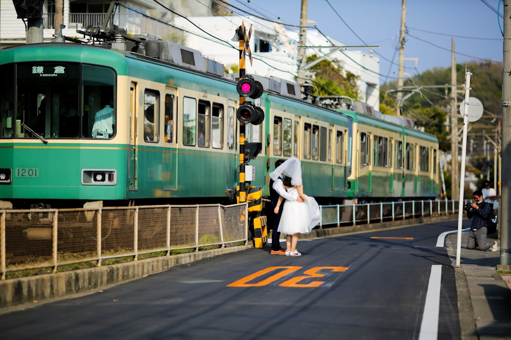 a woman in a white dress standing next to a train