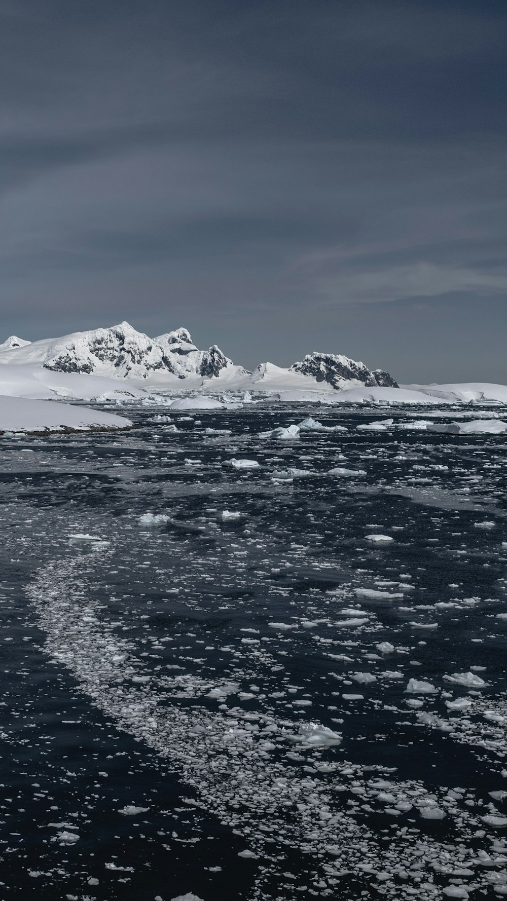 a large body of water surrounded by snow covered mountains