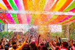 a crowd of people standing under a colorful canopy